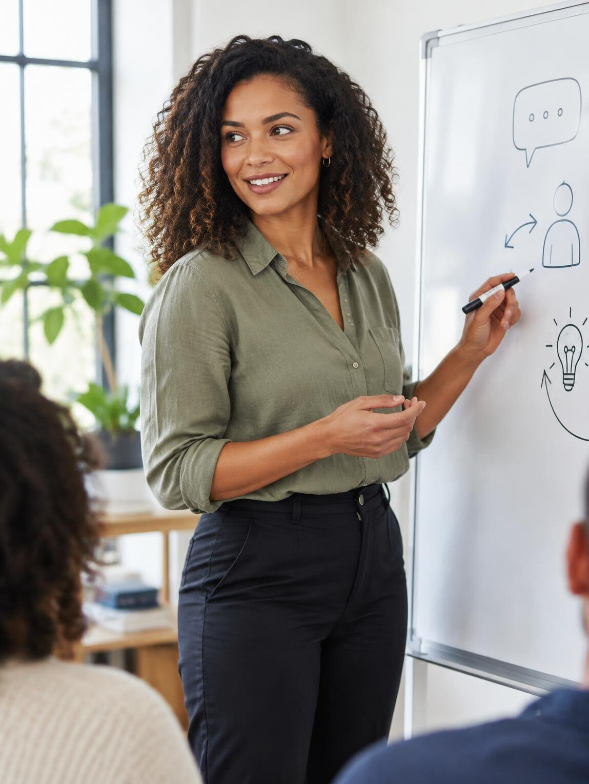 Facilitadora brasileira conduzindo uma dinâmica de comunicação em um quadro branco